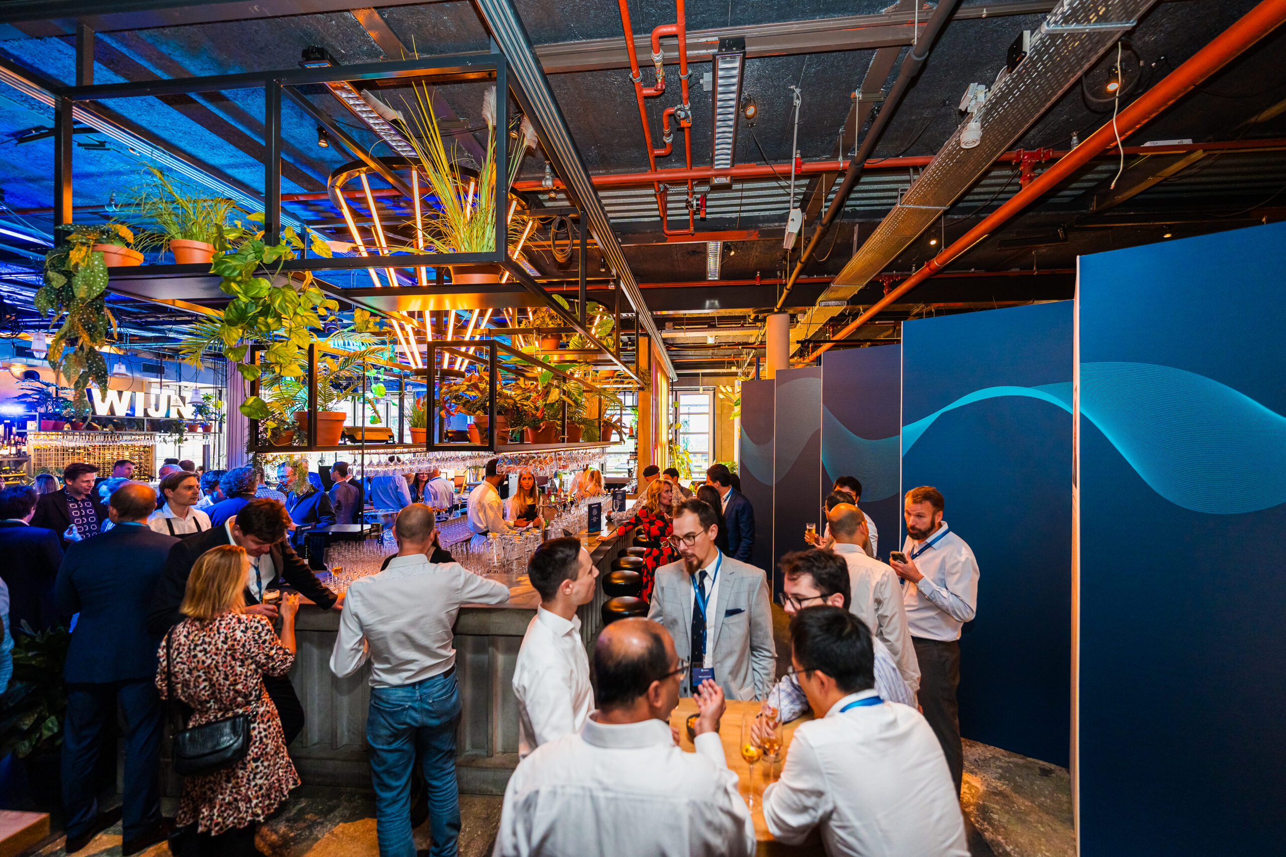 Organizing Customer Day - Cozy bar setting with employees and guests during the Statkraft 25th anniversary event, organized by Dutch Standard Events.