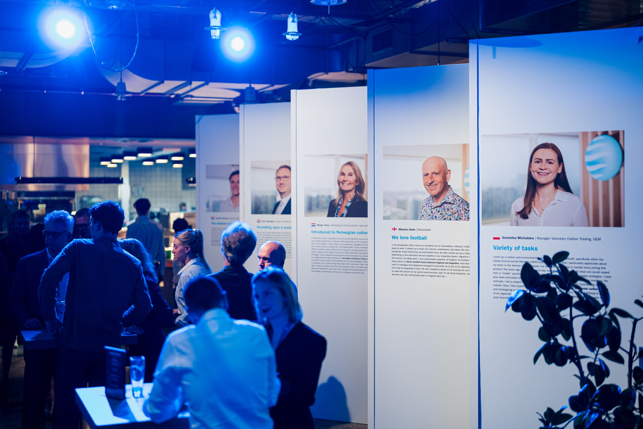 Information booths with Statkraft employees and stories during the 25th anniversary event, surrounded by visitors.