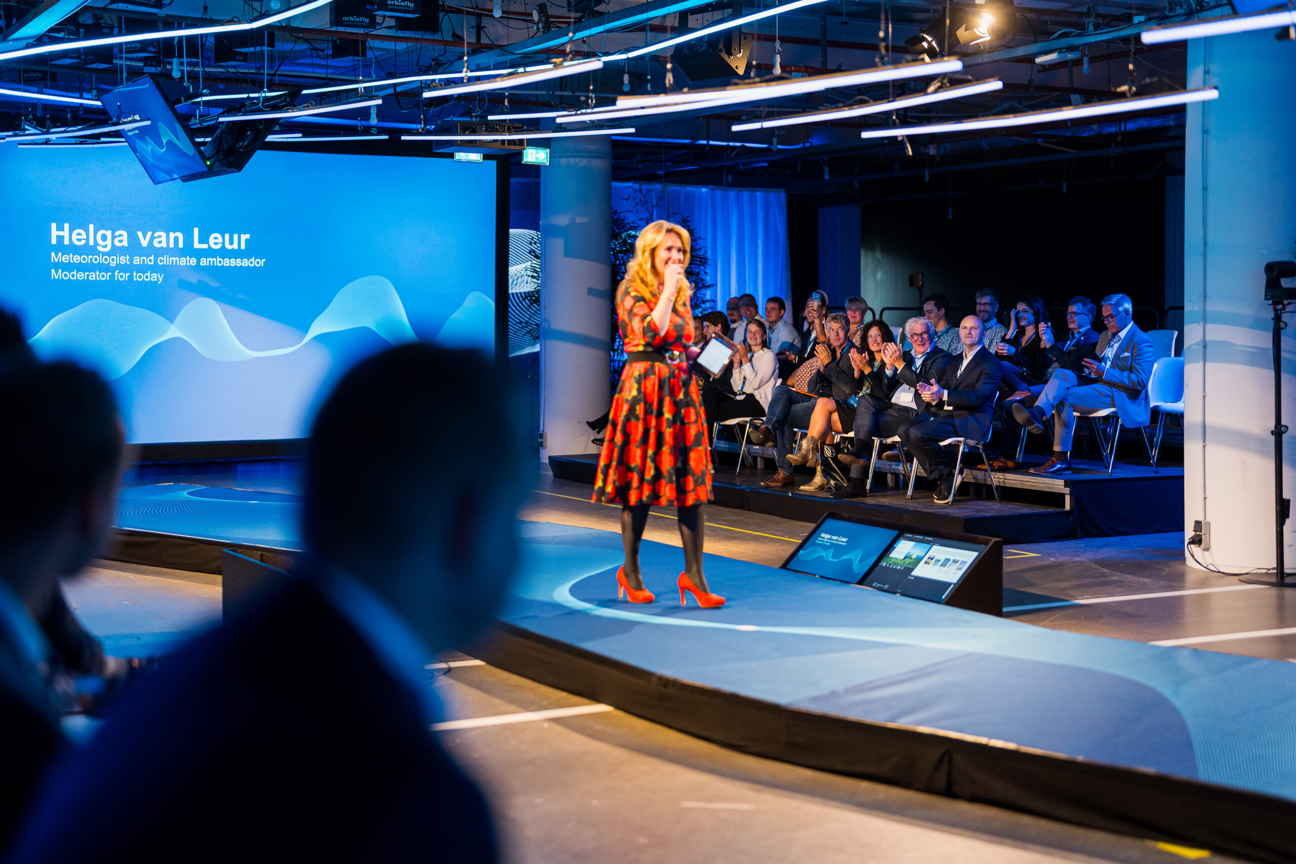 Helga van Leur speaks on stage during the Statkraft 25th anniversary event, to an audience of employees and guests.